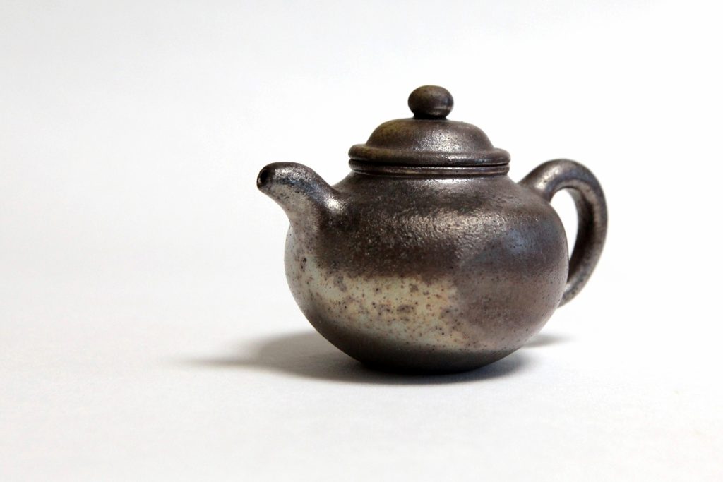 一道茶舍柴烧紫砂壶,圆腹短流,表面呈自然火痕
